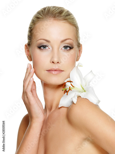 Photo: Beauty face of the young beautiful woman with flower Beauty face of the young beautiful woman with flower