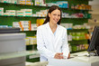 Apothekerin an Kasse mit Medikament