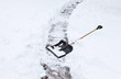 black shovel to remove the snow from the garden path.