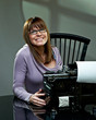Beautiful young woman in glasses at a vintage typewriter Beautiful young woman in glasses at a vintage typewriter
