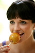 Young Woman Eating a Toffee Apple. Model Released