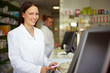 Lachende Apothekerin an der Kasse