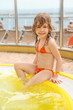 girl wearing swimming suit sitting on edge of swimming pool