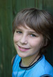 Portrait of the smiling teenager on a green background .