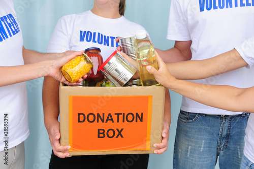 Photo: volunteers putting food in donation box volunteers putting food in donation box