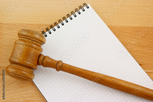 Photo: Blank spiral note pad and gavel on wooden table Blank spiral note pad and gavel on wooden table
