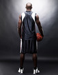 Young sportsman holding a basketball - Rear view