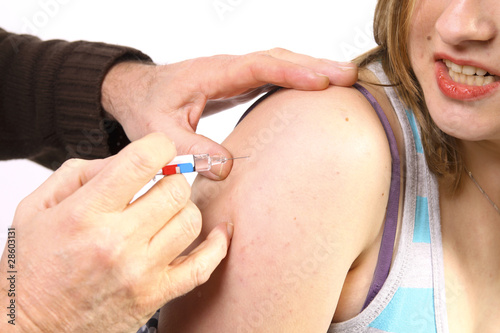 Photo: Young woman getting a vaccine Young woman getting a vaccine