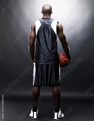 Photo: Young sportsman holding a basketball - Rear view Young sportsman holding a basketball - Rear view