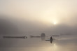 Lone rower in a misty sunrise