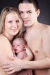 Glückliche Eltern mit Baby blicken auf Sie