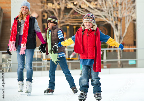 Photo: a family skates together at an ice rink a family skates together at an ice rink