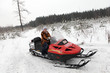 Woman is posing on snowmobile