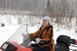Woman on snowmobile in forest
