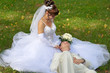 Wedding couple of young men cuddling on the grass