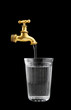 Old metal faucet and glass isolated on black