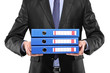 A close up of a businessman holding three blue folders