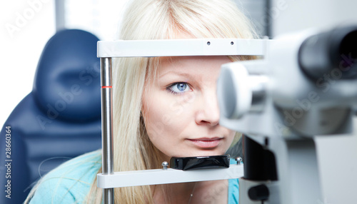 Photo: optometry concept - pretty young woman having her eyes examined optometry concept - pretty young woman having her eyes examined