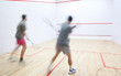 Squash players in action on a squash court (motion blurred image Squash players in action on a squash court (motion blurred image