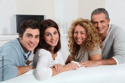 Photo: Group of friends sitting in sofa watching tv Group of friends sitting in sofa watching tv