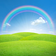 Green field with blue sky and perfect rainbow