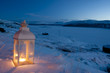 Burning lantern in the snow at dusk Burning lantern in the snow at dusk