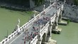 Front view on many people passing across Bridge