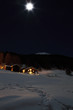 chalet montano con neve e luna piena