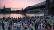 Dancing people on the square near the bridge.