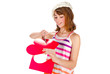 Cute girl in cap cutting valentine heart out of red paper
