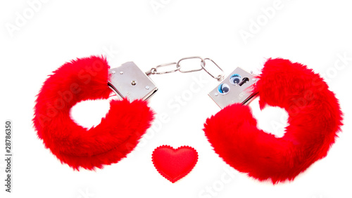 Photo: red soft sexual handcuffs with a heart isolated over white red soft sexual handcuffs with a heart isolated over white