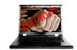 Laptop with fist punching thru a brick wall
