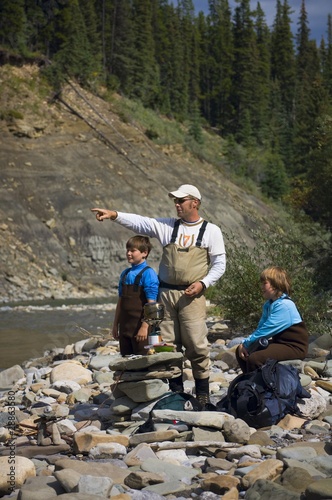 Photo: Father And Sons On River Shoreline Father And Sons On River Shoreline