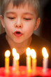 Boy blowing out candles on birthday cake