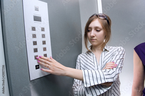 Photo: A teenage girl pushing an elevator button A teenage girl pushing an elevator button