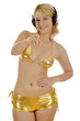 Junge Frau im Goldbikini und Kopfhörern zeigt Junge Frau im Goldbikini und Kopfhörern zeigt