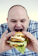 Foto: Mann mit Cheeseburger Mann mit Cheeseburger