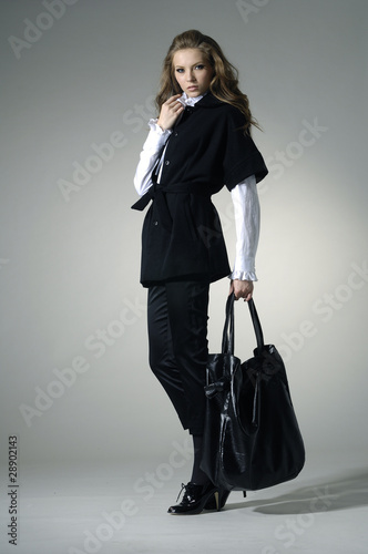 Foto: Fashion girl with bag posing in the studio Fashion girl with bag posing in the studio
