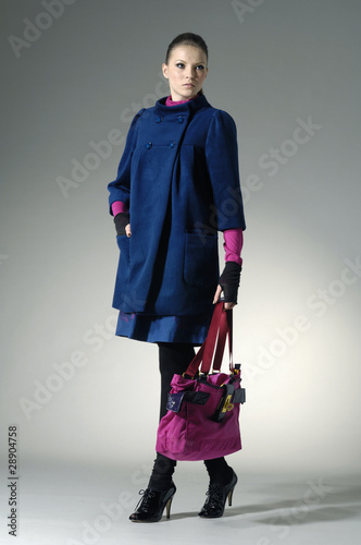 Photo: Fashion girl with bag posing in the studio Fashion girl with bag posing in the studio