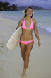 blond girl in pink bikini with surfboard on a hawaii beach