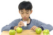 Little boy drinking Milk with green apple at the Table