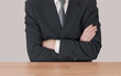 Inaction concept - man at desk with arms crossed