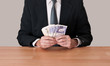 Photo: Man in suit sitting with cash - pounds sterling Man in suit sitting with cash - pounds sterling