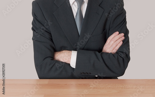 Photo: Inaction concept - man at desk with arms crossed Inaction concept - man at desk with arms crossed