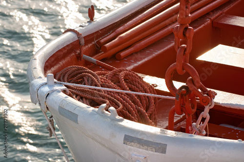 Photo: Closeup lifeboat with a rope on the sea. Closeup lifeboat with a rope on the sea.