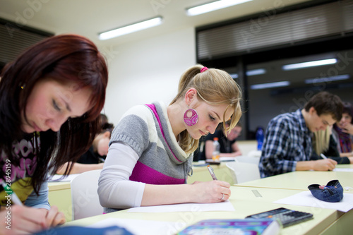 Photo: pretty female college student sitting in a classroom pretty female college student sitting in a classroom