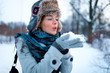 Portrait of beautiful young girl blowing on snow