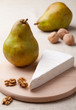 Green pears, cheese brie, cores of walnuts on wooden board