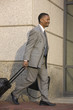 Photo: Businessman walking with a briefcase and suitcase Businessman walking with a briefcase and suitcase