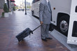 Businessman with suitcase getting into a bus